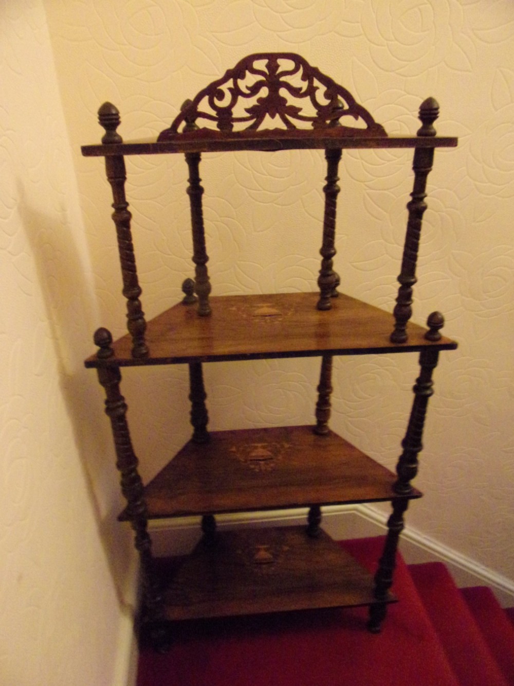 A Victorian walnut tiered whatnot stand featuring four tiers with satinwood urn inlay, turned column supports, and a pierced decorative gallery crest. View VI