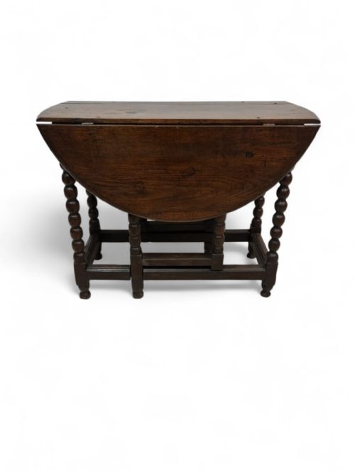 fig 1. A mid-19th century Victorian oak drop-leaf table with bobbin-turned legs and a warm brown wood finish.