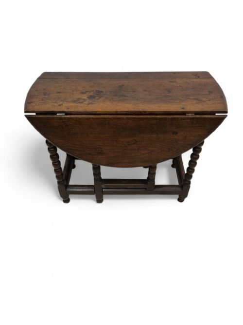 fig 2. A mid-19th century Victorian oak drop-leaf table with bobbin-turned legs and a warm brown wood finish.