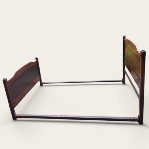 fig 1. A solid oak small double bed frame featuring a panelled headboard and footboard with central carved motifs.