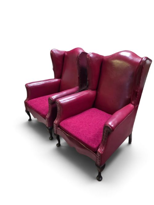 fig 1. A pair of 1930s burgundy leather wingback armchairs featuring patterned fabric seat cushions, studded trim, and dark timber cabriole legs.
