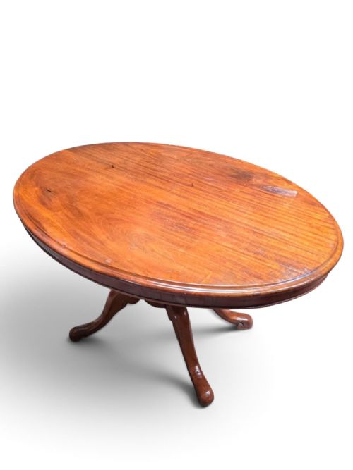 fig 1. An antique oval mahogany dining table featuring a central turned pedestal shaft supported by four splayed legs.