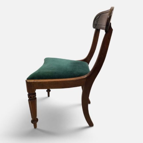 fig 1. A pair of antique Regency mahogany dining chairs featuring curved carved crest rails and green velvet upholstered seats.