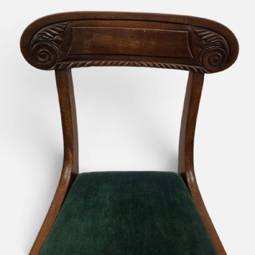 fig 2. A pair of antique Regency mahogany dining chairs featuring curved carved crest rails and green velvet upholstered seats.