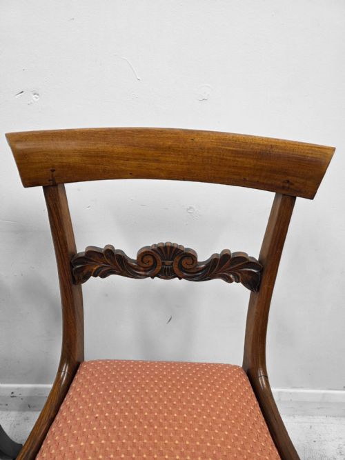fig 2. A pair of late Regency mahogany dining chairs featuring carved back rails, turned fluted legs, and patterned rose pink upholstered seats.