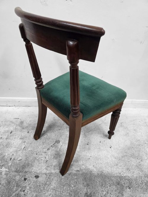 fig 1. A set of four Victorian mahogany dining chairs featuring curved crest rails, turned front legs, and green velvet upholstered seats.