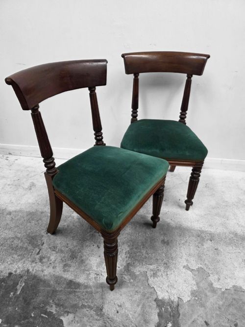 fig 2. A set of four Victorian mahogany dining chairs featuring curved crest rails, turned front legs, and green velvet upholstered seats.