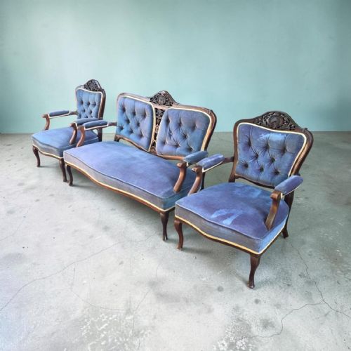 fig 2. A three-piece antique salon suite including a two-seater settee and two matching armchairs upholstered in purple velvet with carved timber frames.