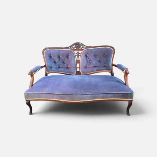 fig 3. A three-piece antique salon suite including a two-seater settee and two matching armchairs upholstered in purple velvet with carved timber frames.