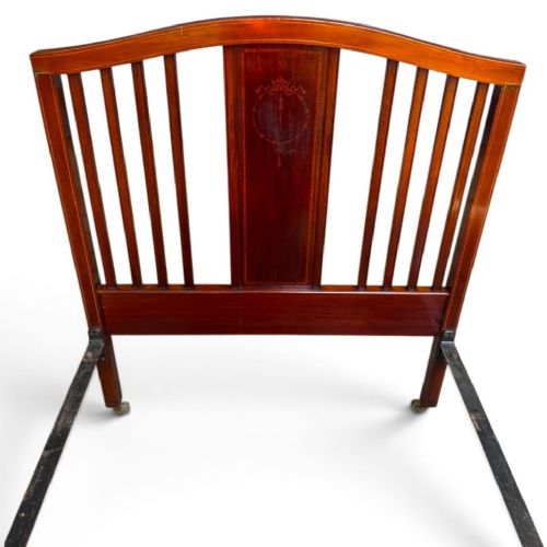 fig 1. An antique Edwardian mahogany single bed frame featuring a slatted headboard and footboard with central inlaid wood panels and castors.