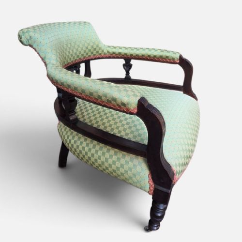 fig 1. A late Victorian tub chair with a dark carved mahogany frame and green patterned fabric upholstery.
