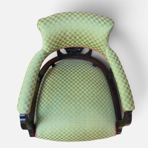 fig 3. A late Victorian tub chair with a dark carved mahogany frame and green patterned fabric upholstery.