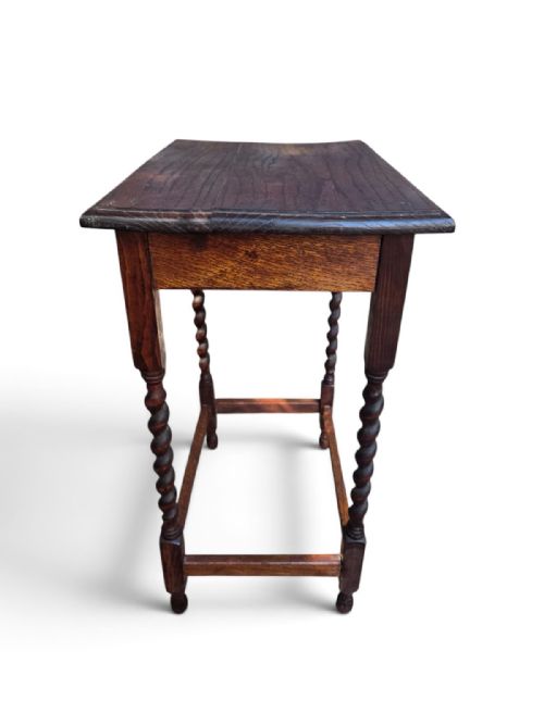 fig 1. An antique dark oak rectangular side table featuring four turned barley twist legs connected by a low box stretcher.