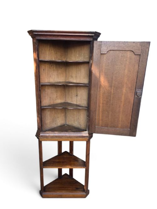 fig 2. A late Victorian English oak corner cupboard featuring a fielded panel door above an open two-tiered stand.