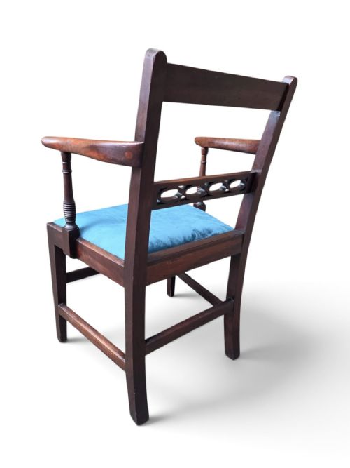 fig 2. A Victorian mahogany open armchair featuring a reeded top rail, turned arm supports, and a blue upholstered seat.