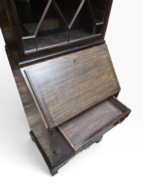 fig 1. An Edwardian dark mahogany bureau bookcase featuring an upper cabinet with astragal glazed doors, a slant-front writing slope, and a lower door cupboard on bracket feet.
