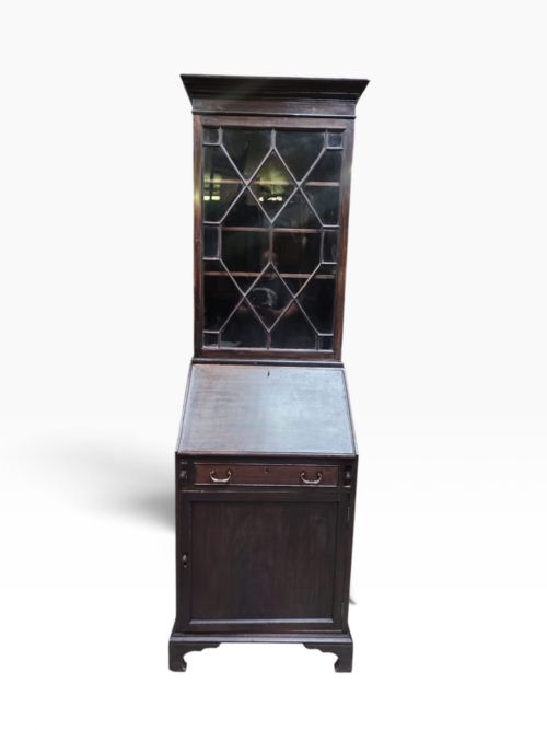 fig 4. An Edwardian dark mahogany bureau bookcase featuring an upper cabinet with astragal glazed doors, a slant-front writing slope, and a lower door cupboard on bracket feet.