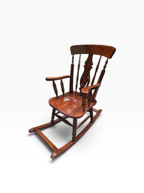 fig 1. An antique Victorian mahogany Windsor rocking chair featuring turned spindles, a shaped central splat, armrests, and wooden rocker runners.