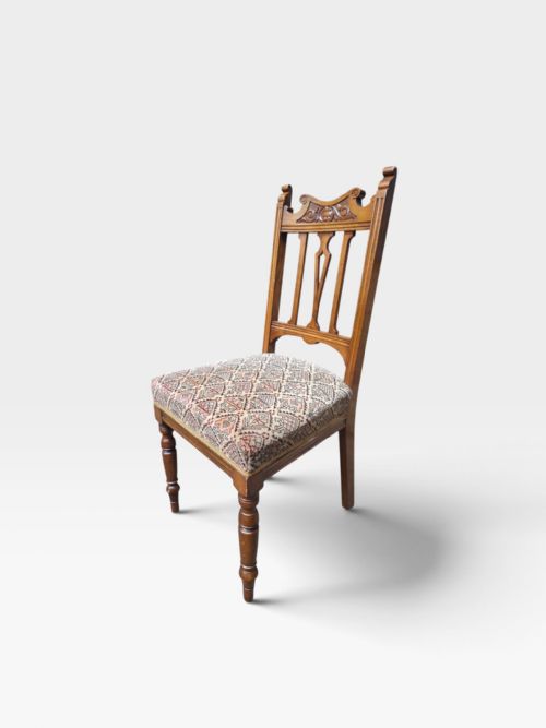 fig 2. A set of six Edwardian oak dining chairs featuring carved cresting rails, vertical splat backs, turned front legs, and patterned fabric seats.