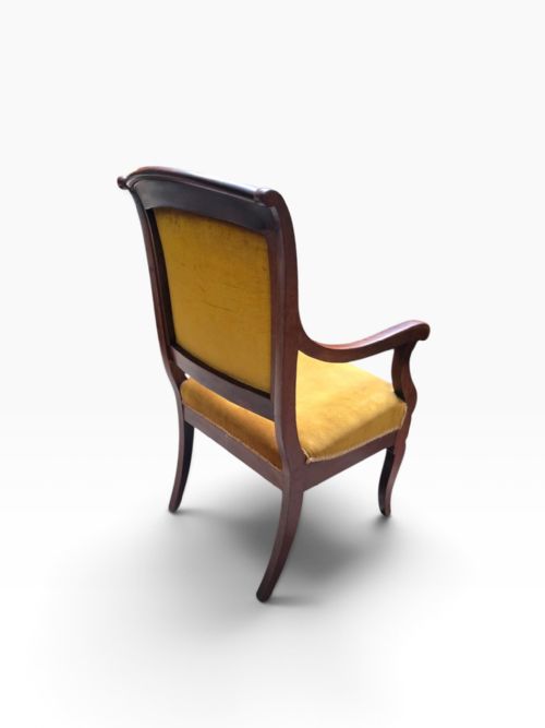 fig 1. A late Victorian mahogany carver armchair featuring curved armrests and mustard yellow velvet upholstery on the seat and backrest.