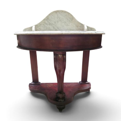 fig 1. A Victorian mahogany washstand featuring a curved white marble top with a splashback and a single carved scroll front leg.