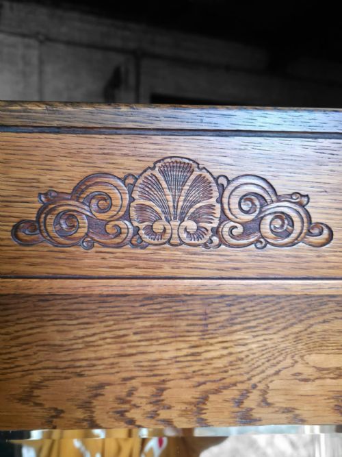 fig 4. An antique 1920s Art Deco oak wardrobe featuring a central mirrored door, geometric inlay detailing, and carved accents.