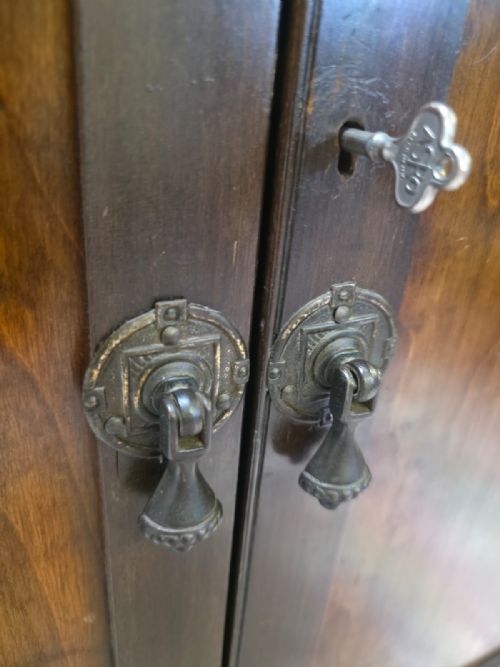 fig 1. An antique Edwardian dark mahogany side cabinet with two panelled doors, square tapered legs, a low upstand back, and original key.