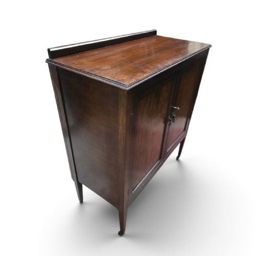fig 2. An antique Edwardian dark mahogany side cabinet with two panelled doors, square tapered legs, a low upstand back, and original key.