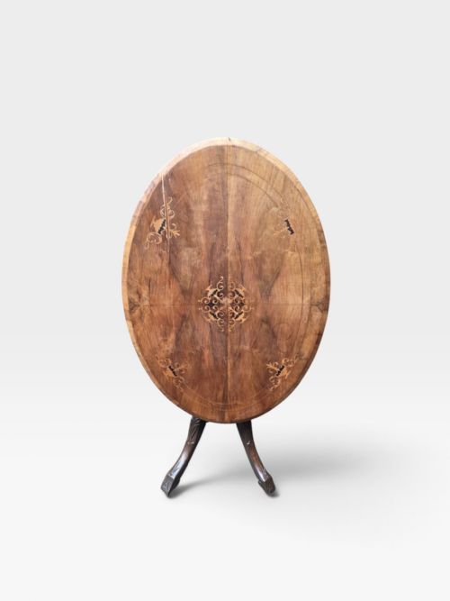 fig 3. An antique Victorian circular walnut centre table featuring central marquetry inlay and a carved pedestal base with four legs.