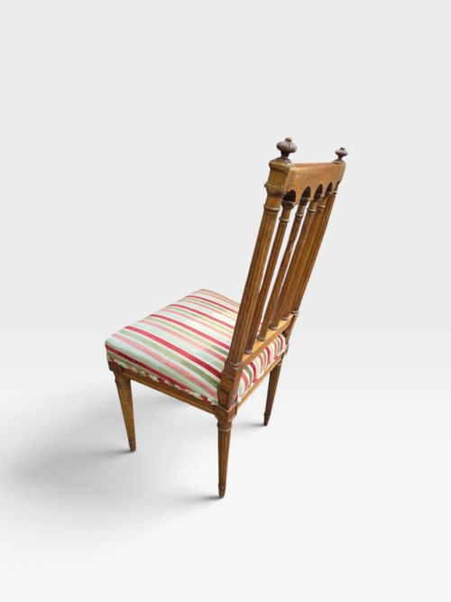 fig 1. A set of four Edwardian mahogany dining chairs with arcade-slatted backrests, fluted legs, and striped fabric seat cushions.