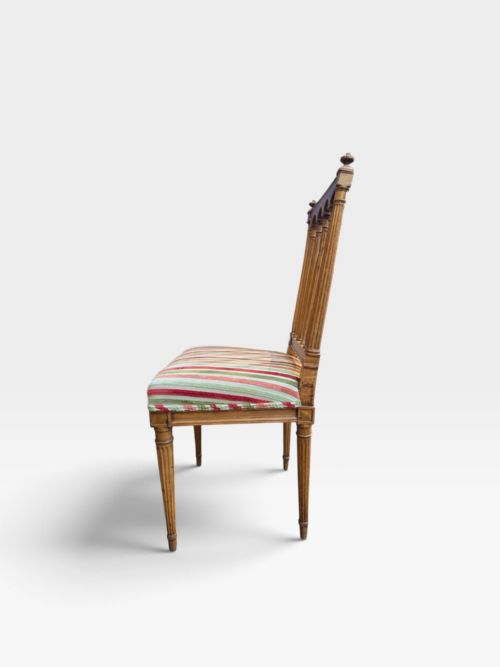 fig 2. A set of four Edwardian mahogany dining chairs with arcade-slatted backrests, fluted legs, and striped fabric seat cushions.