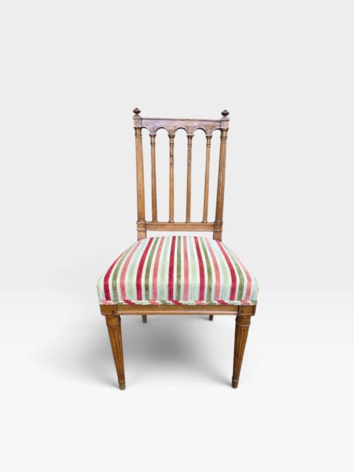 fig 3. A set of four Edwardian mahogany dining chairs with arcade-slatted backrests, fluted legs, and striped fabric seat cushions.