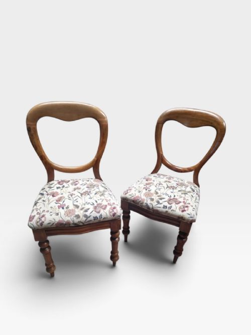 fig 1. Set of four Victorian mahogany dining chairs featuring open rounded balloon backrests, turned front legs, and floral fabric upholstered seats.