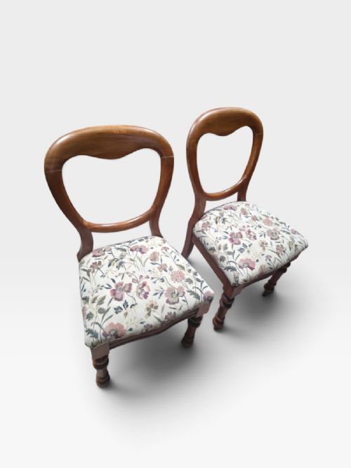 fig 2. Set of four Victorian mahogany dining chairs featuring open rounded balloon backrests, turned front legs, and floral fabric upholstered seats.