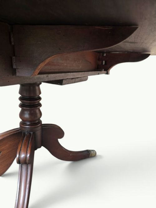 fig 3. A William IV mahogany Pembroke table featuring drop-leaf flaps, a central turned pedestal, and four splayed legs with brass paw feet.