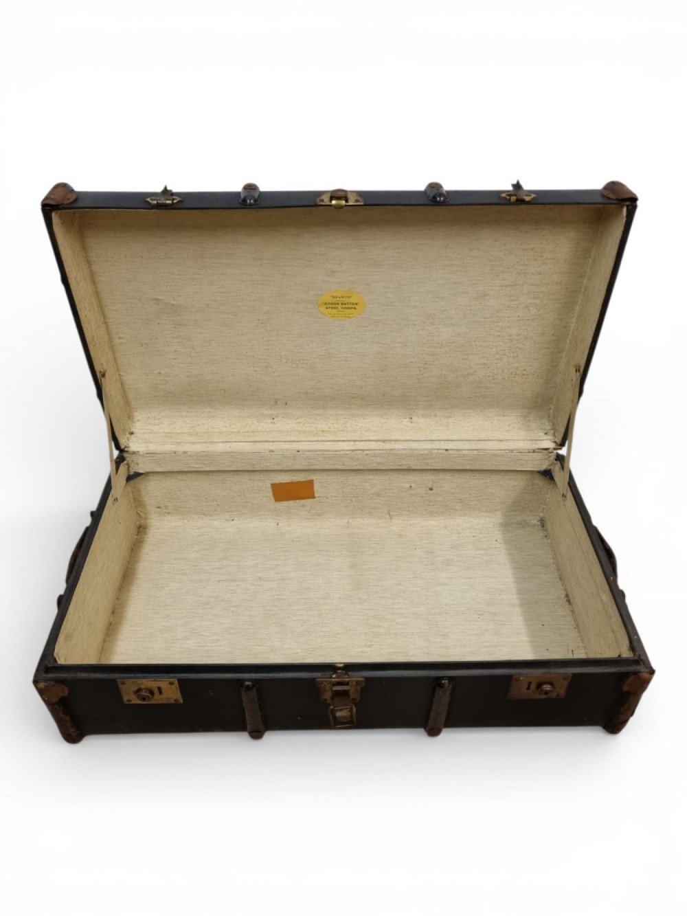 A rectangular black travel trunk featuring dark wooden reinforcement bands, brass latches, and reinforced metal corner caps. View V