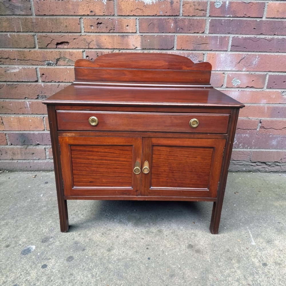 A late Victorian mahogany chiffonier side cabinet with a shaped gallery back, a single drawer, and two panelled cupboard doors with brass handles.