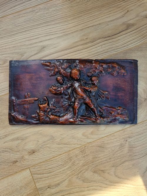 A 18THC WALNUT CARVED PANEL OF CHILDREN PLAYING