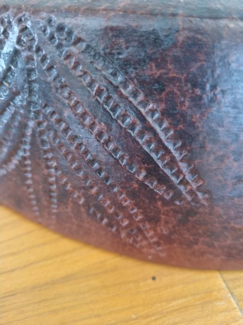 fig 1. An oval 19th-century reddish-brown stoneware cooking dish featuring incised leaf patterns carved along the exterior side.