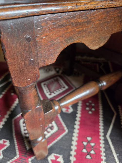 fig 1. An 18th-century dark oak side chair featuring a vase-shaped splat back, solid timber seat, and turned front legs and stretcher.