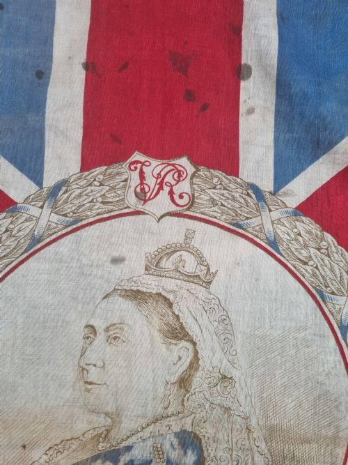 fig 1. A square printed Union Jack flag featuring a central circular portrait of Queen Victoria inscribed with the dates 1837 to 1897.