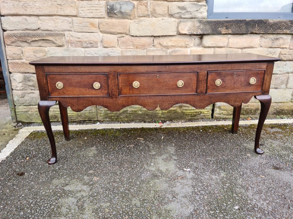 A 18THCENTURY OAK LOW DRESSER ON CABRIOLE LEGS 