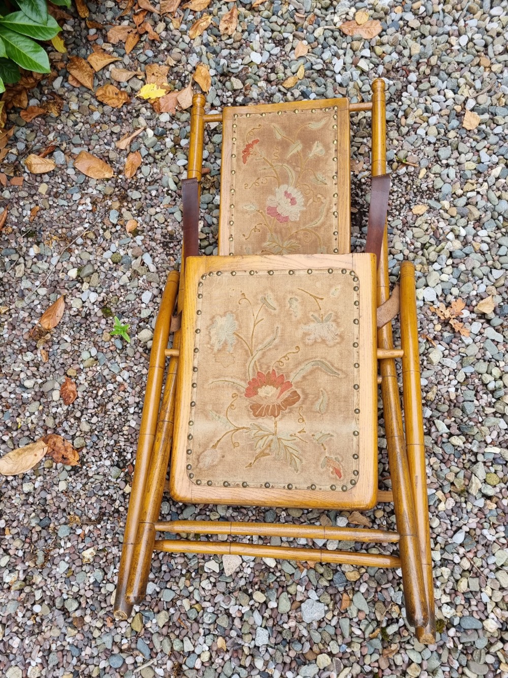 A 19th-century light oak folding lounge chair with floral tapestry panels, leather strap armrests, and an extended footrest. View III