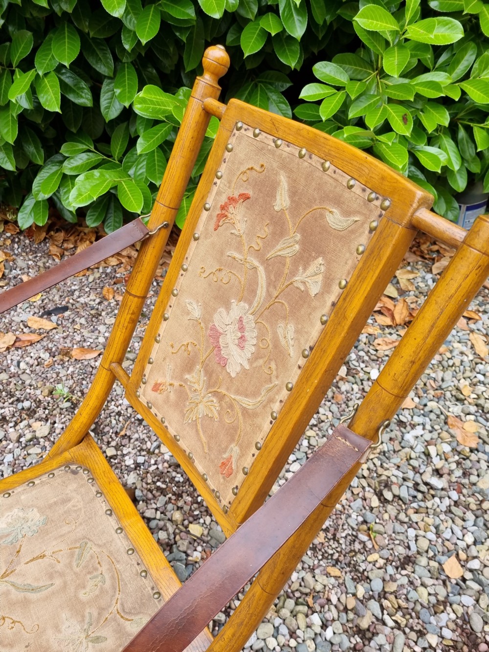 A 19th-century light oak folding lounge chair with floral tapestry panels, leather strap armrests, and an extended footrest. View VI