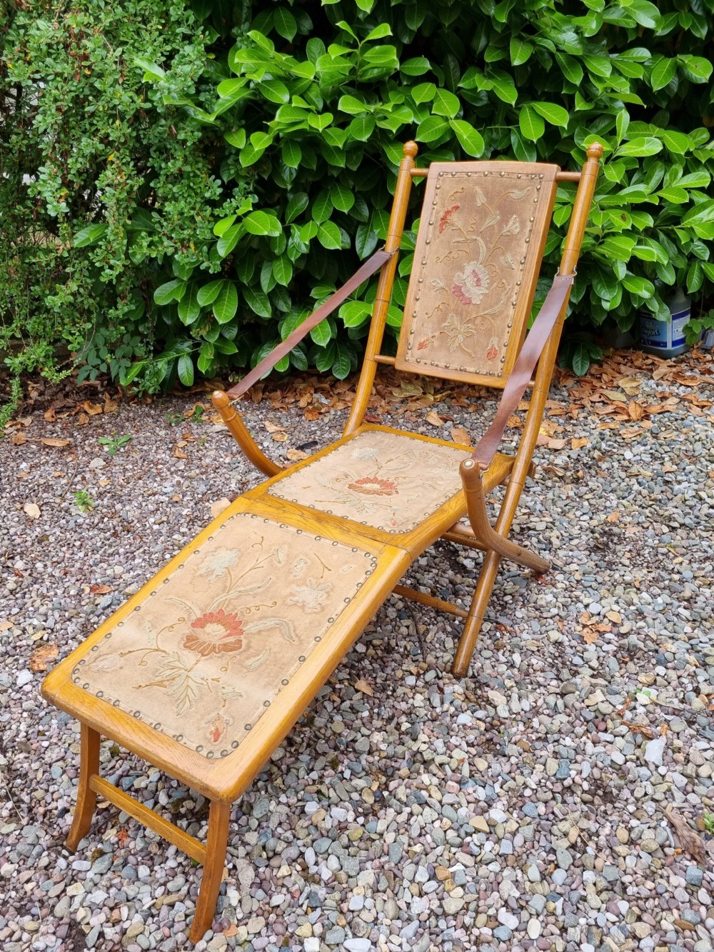 A 19th-century light oak folding lounge chair with floral tapestry panels, leather strap armrests, and an extended footrest. View VII