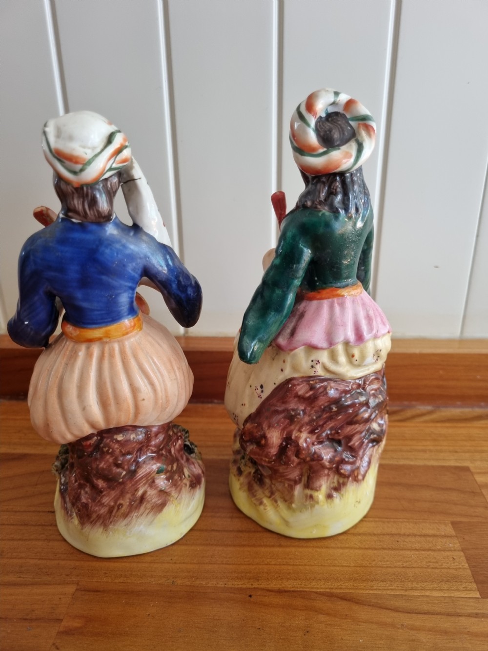A pair of nineteenth-century Staffordshire earthenware figures depicting a seated male and female musician in colourful orientalist costume playing lutes. View V