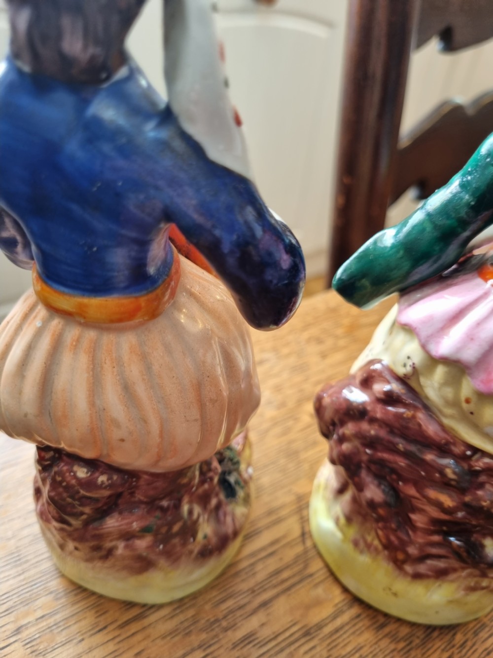 A pair of nineteenth-century Staffordshire earthenware figures depicting a seated male and female musician in colourful orientalist costume playing lutes. View VII