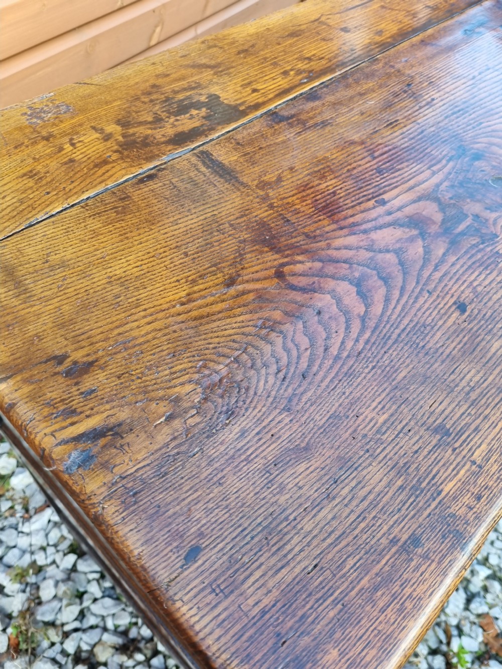 A mid-18th century dark oak dresser base featuring three top drawers over three fielded panel cupboard doors with brass swan neck handles. View VII