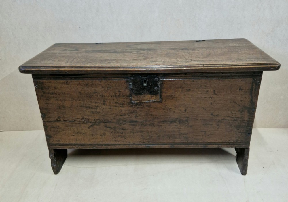 A SMALL OAK 17TH COFFER WITH ORIGINAL WIRE HINGES