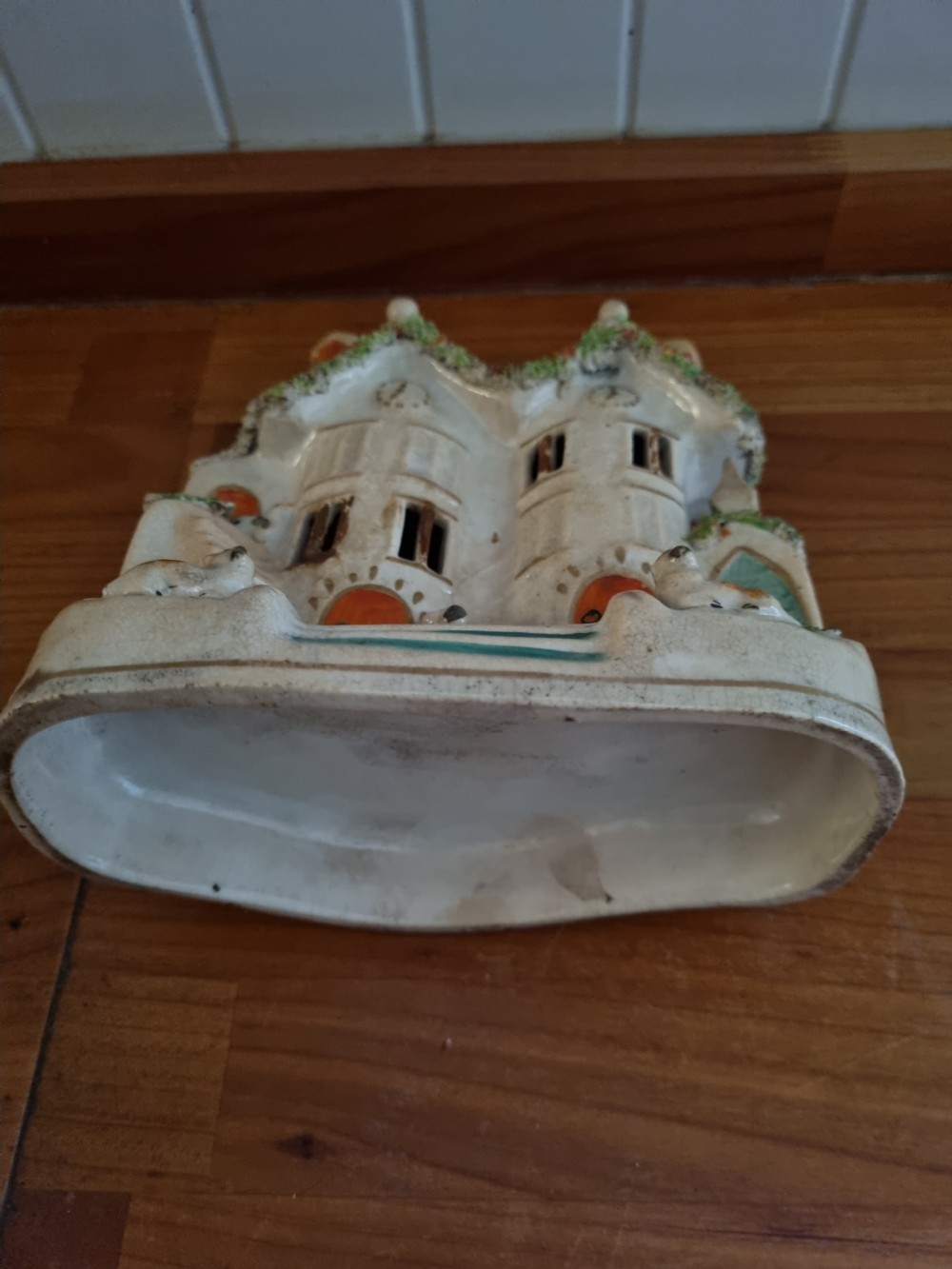 A 19th-century Staffordshire earthenware pastille burner styled as a cream twin-gabled mansion with applied green foliage and painted red doors. View III